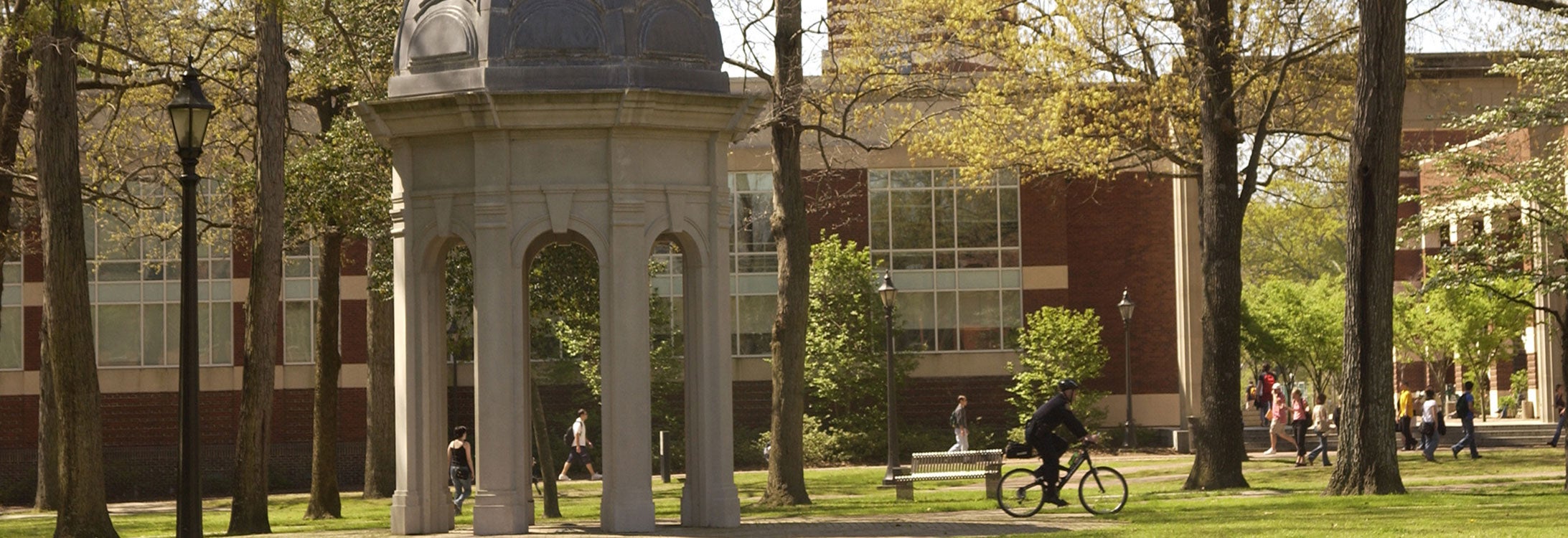 Image of student riding a bike past the cupola